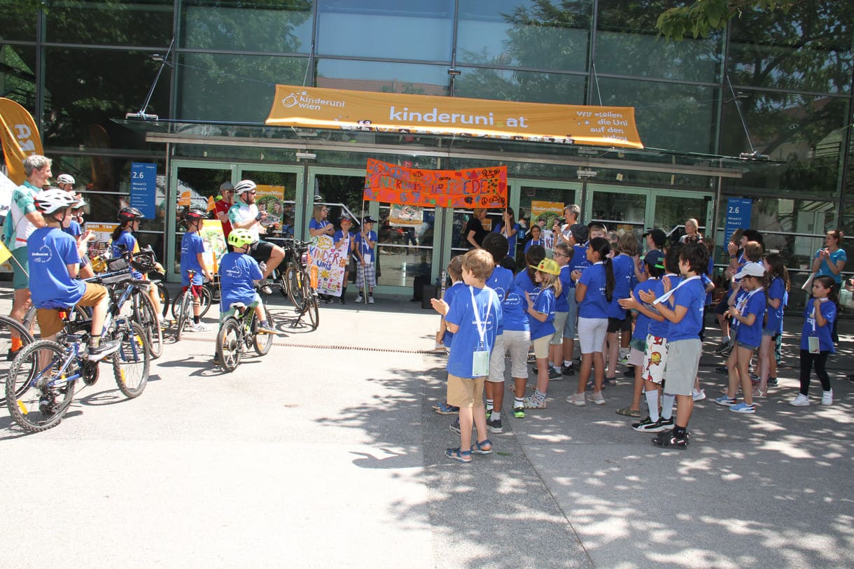 Großes Hallo mit Transparent, Plakaten, Jubel und Reden zum Abschluss der Friedens-Radfahrt am Campus der Uni Wien