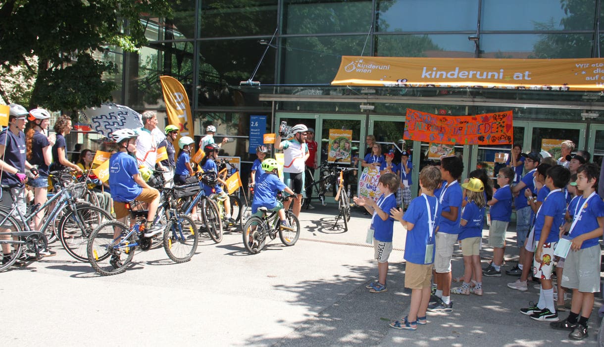 Großes Hallo mit Transparent, Plakaten, Jubel und Reden zum Abschluss der Friedens-Radfahrt am Campus der Uni Wien