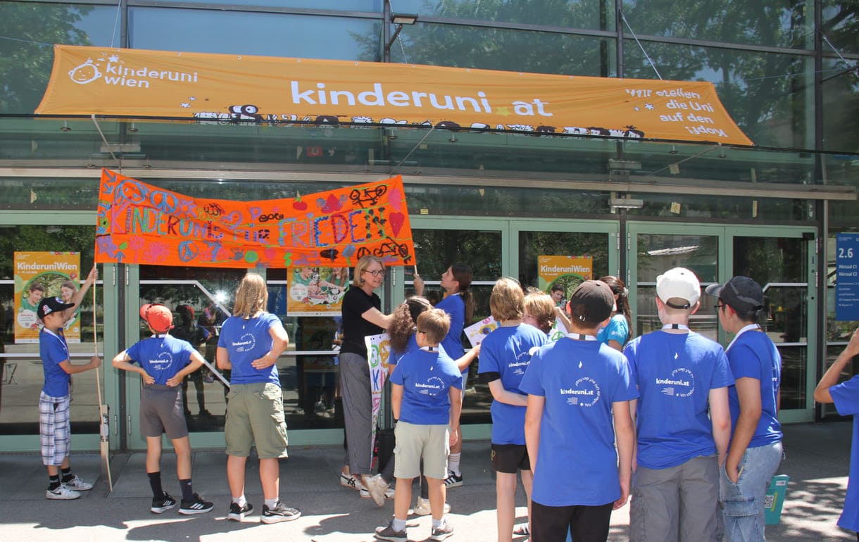 Großes Hallo mit Transparent, Plakaten, Jubel und Reden zum Abschluss der Friedens-Radfahrt am Campus der Uni Wien