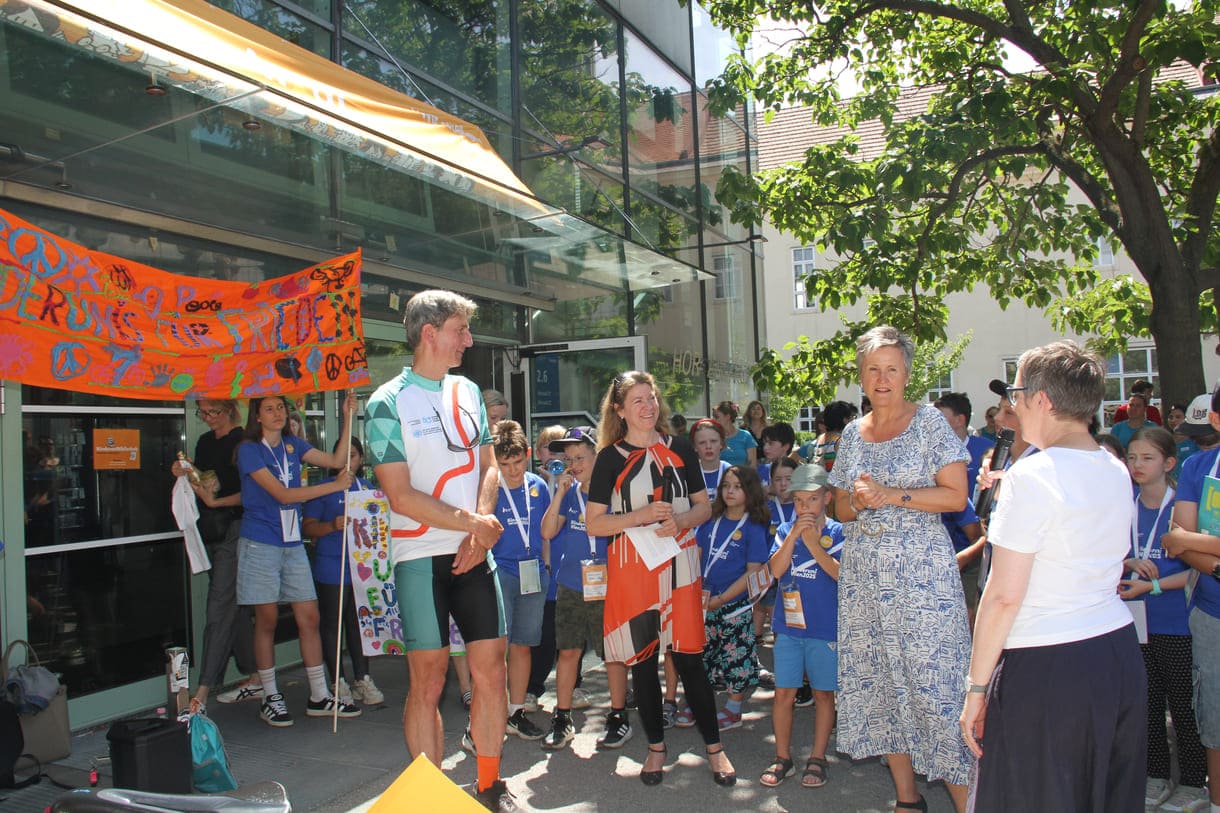 Großes Hallo mit Transparent, Plakaten, Jubel und Reden zum Abschluss der Friedens-Radfahrt am Campus der Uni Wien