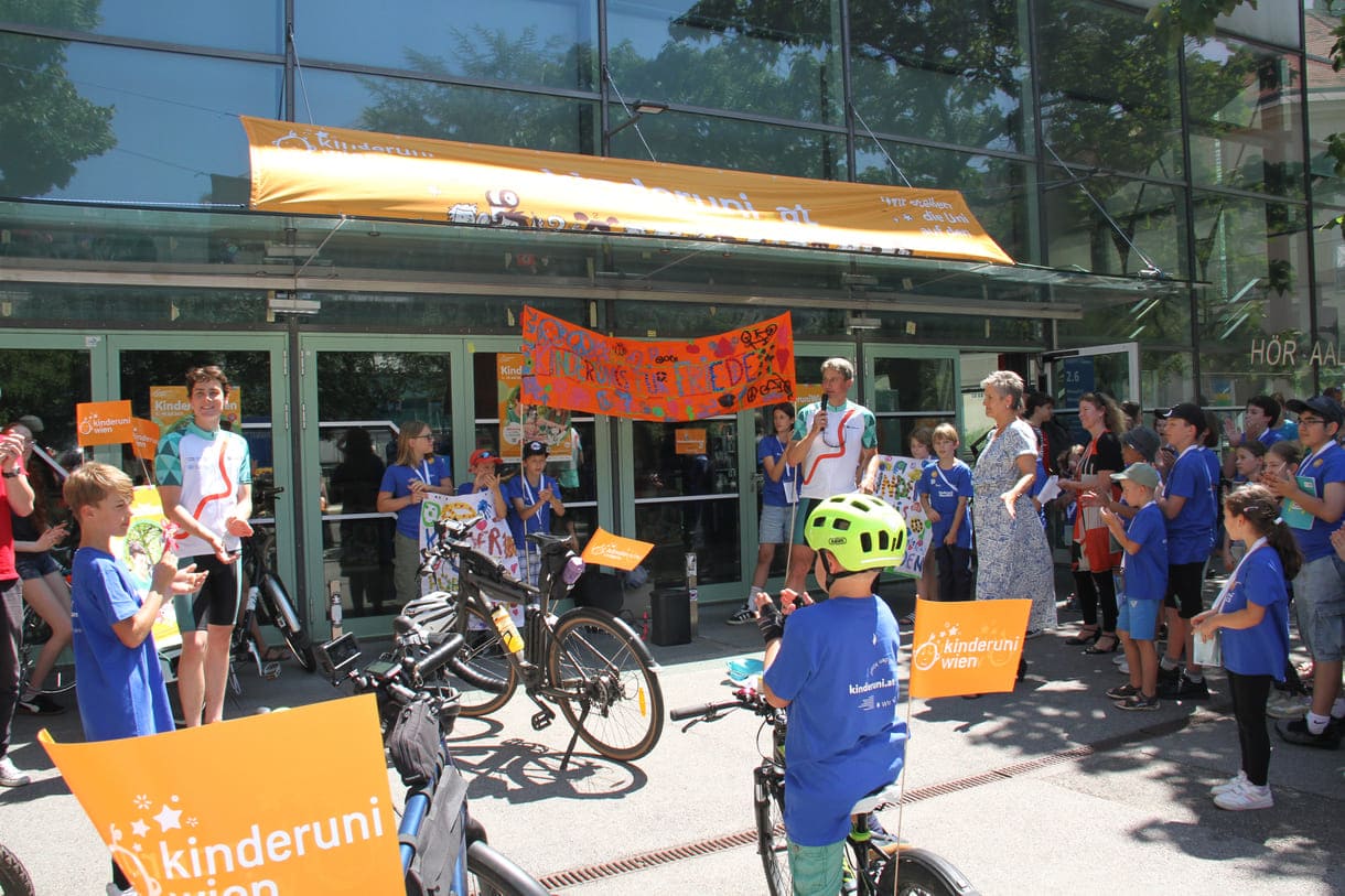 Großes Hallo mit Transparent, Plakaten, Jubel und Reden zum Abschluss der Friedens-Radfahrt am Campus der Uni Wien
