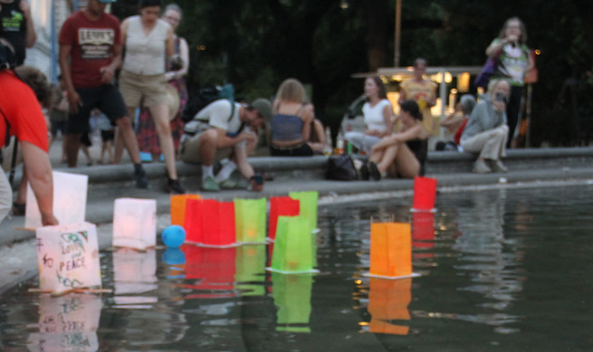 Laternen werden aufs Wasser des Teiches am Karlsplatz gesetzt