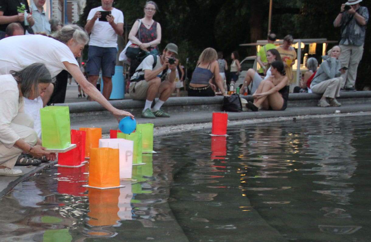 Laternen werden aufs Wasser des Teiches am Karlsplatz gesetzt