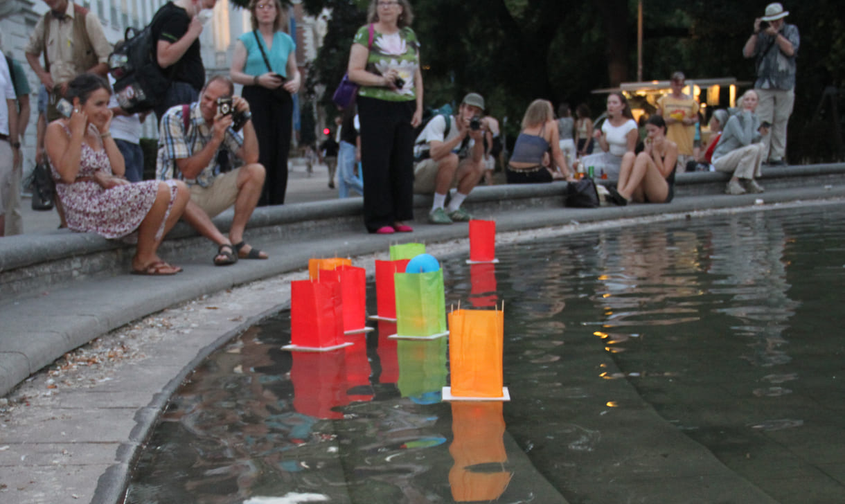 Laternen werden aufs Wasser des Teiches am Karlsplatz gesetzt