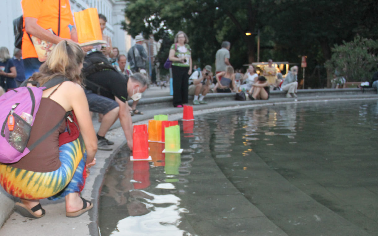 Laternen werden aufs Wasser des Teiches am Karlsplatz gesetzt