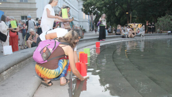 Laternen werden aufs Wasser des Teiches am Karlsplatz gesetzt