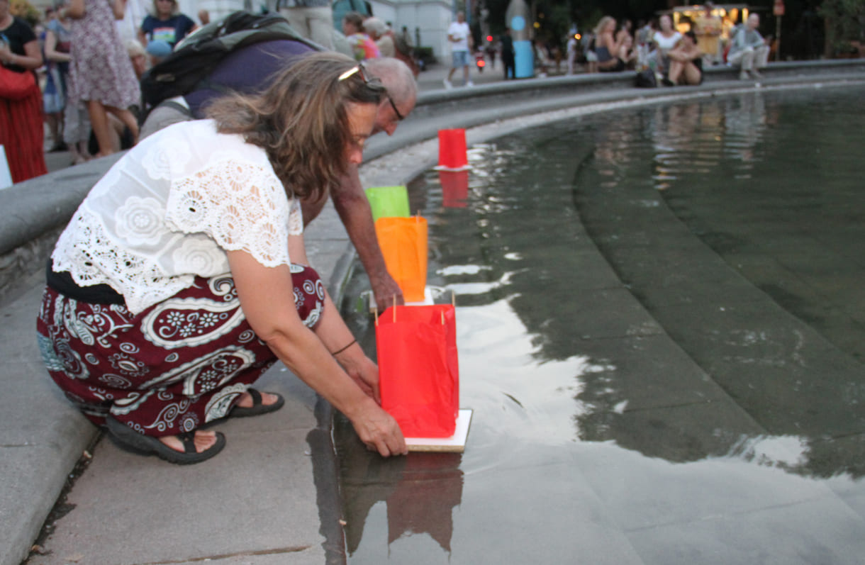Laternen werden aufs Wasser des Teiches am Karlsplatz gesetzt