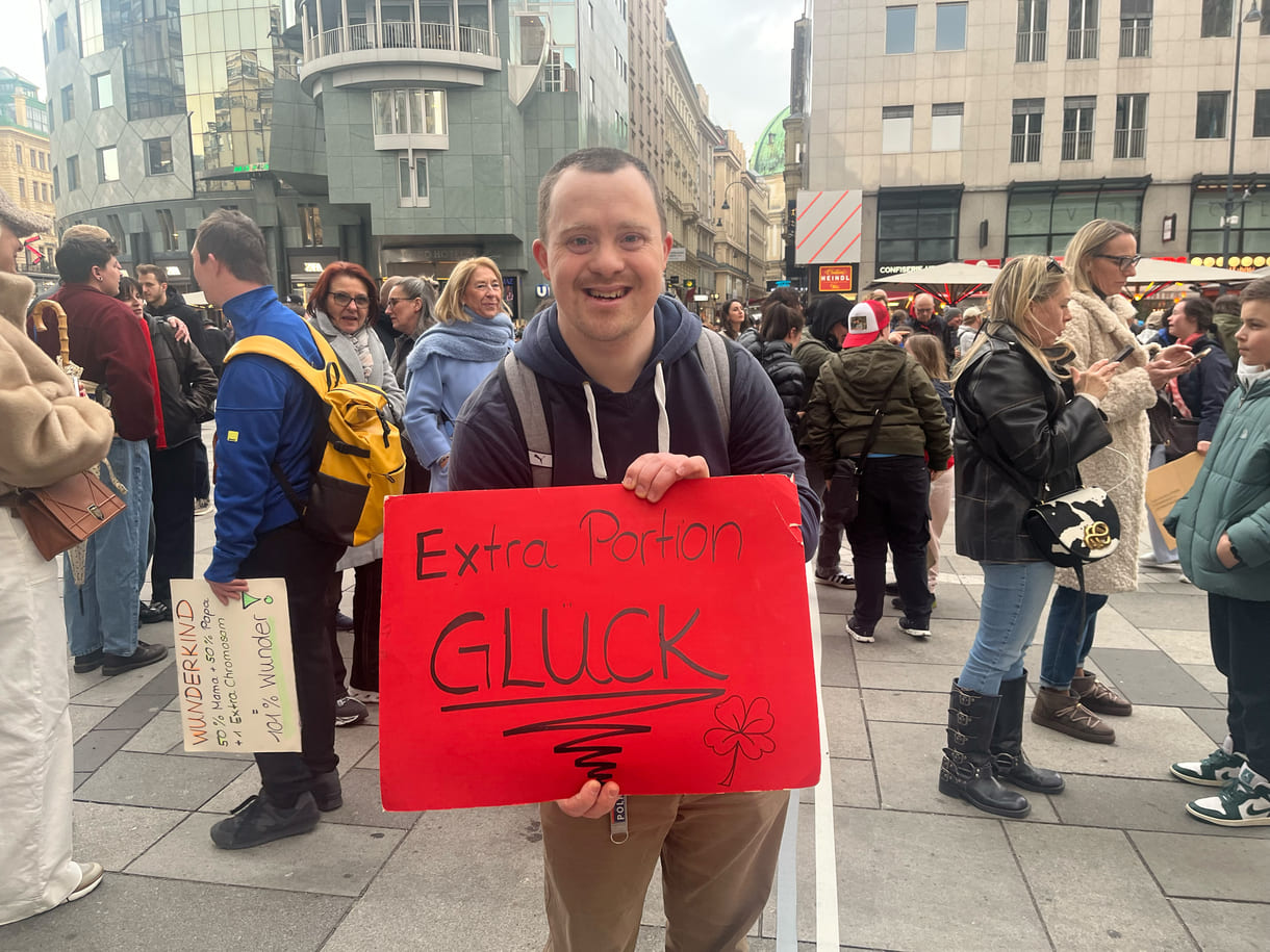 Aktivist:innen mit Kartontafeln mit Hand geschriebenen Sprüchen