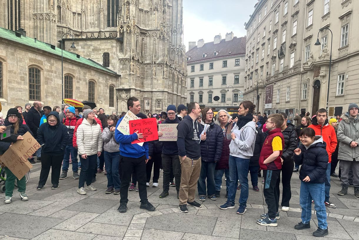 Aktivist:innen mit Kartontafeln mit Hand geschriebenen Sprüchen