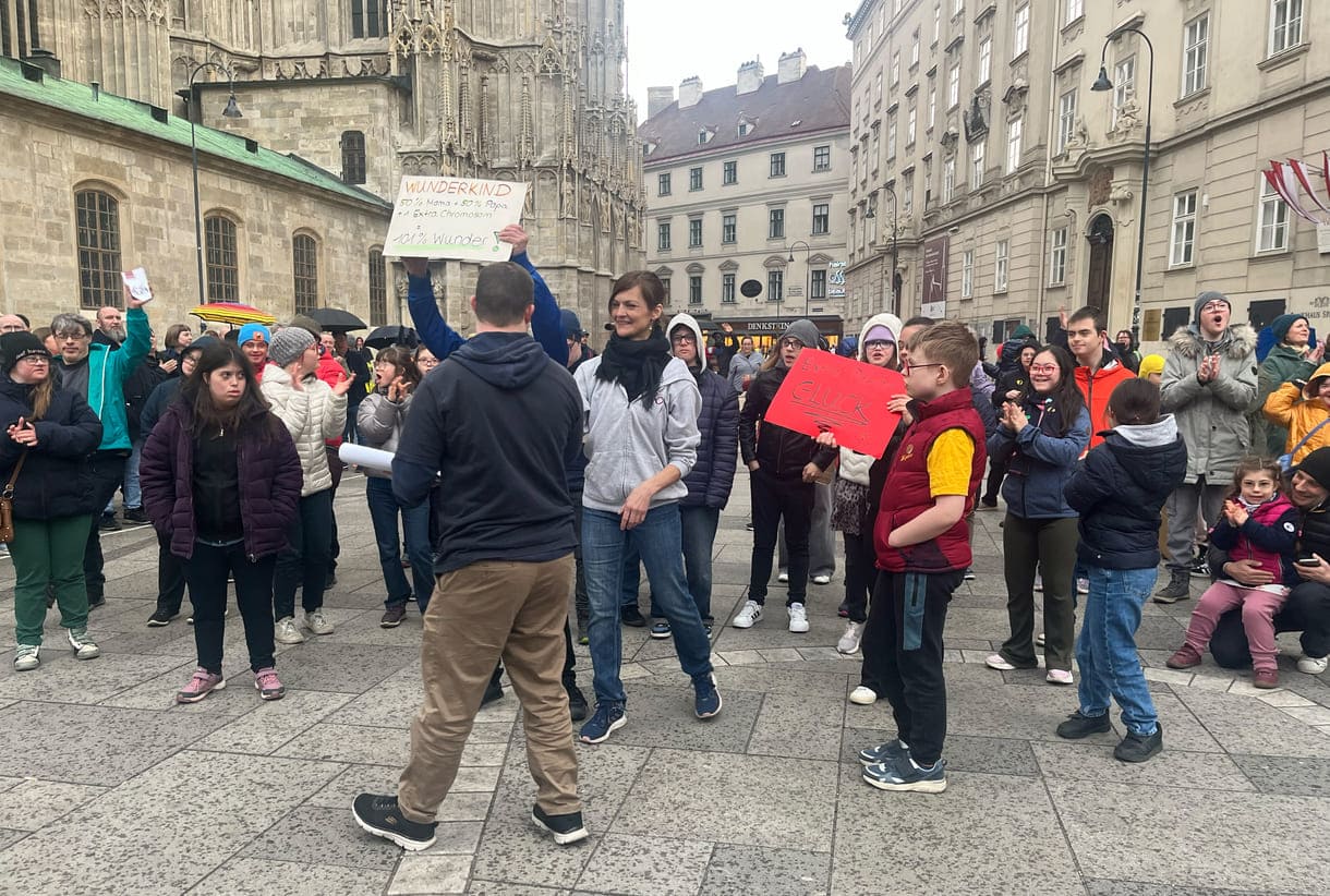 Aktivist:innen mit Kartontafeln mit Hand geschriebenen Sprüchen