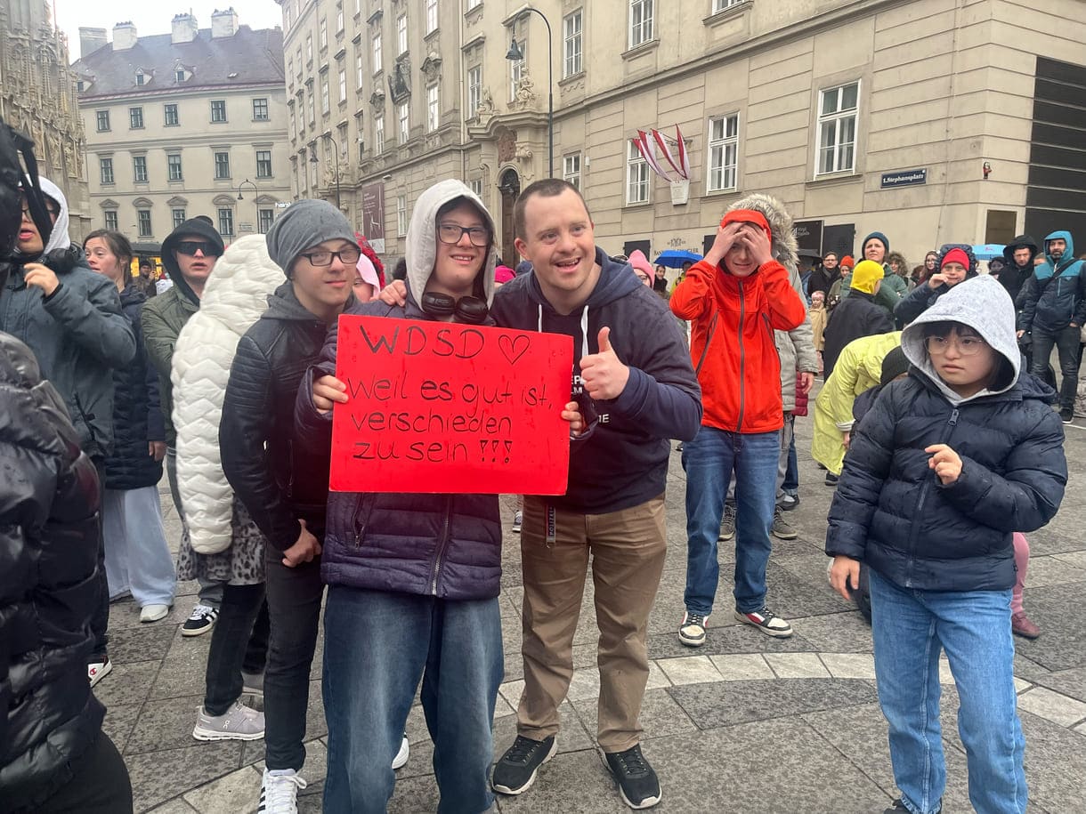 Aktivist:innen mit Kartontafeln mit Hand geschriebenen Sprüchen