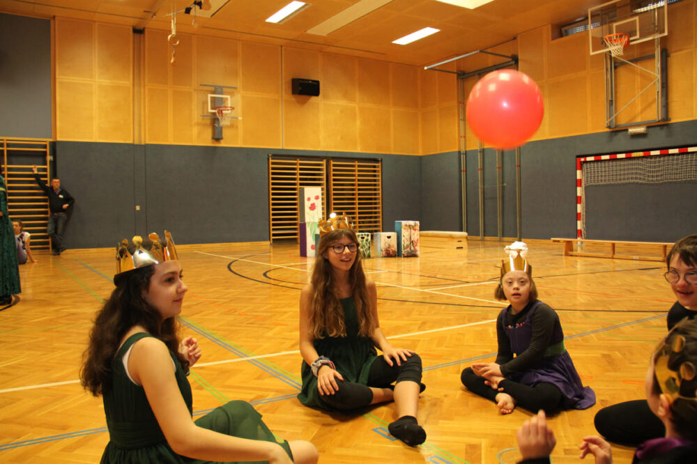 Tänzer:innen, die nciht gerade dran sind, suchen sich stille Beschäftigungen - hier mit Luftballon-Kreisspiel