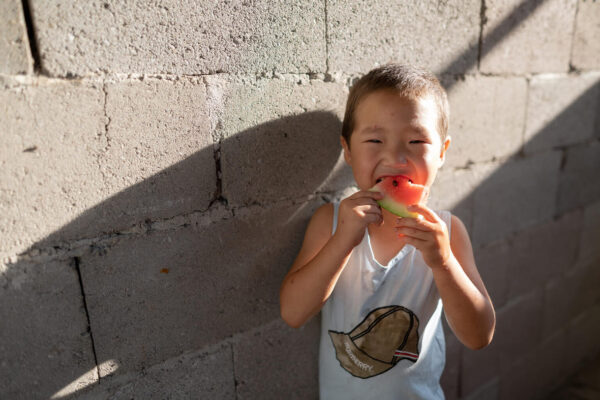 Azamat, 5 Jahre alt, isst am 1. September 2021 zu Hause im Dorf Kurshab, Oblast Osch, Kirgisistan, Wassermelone