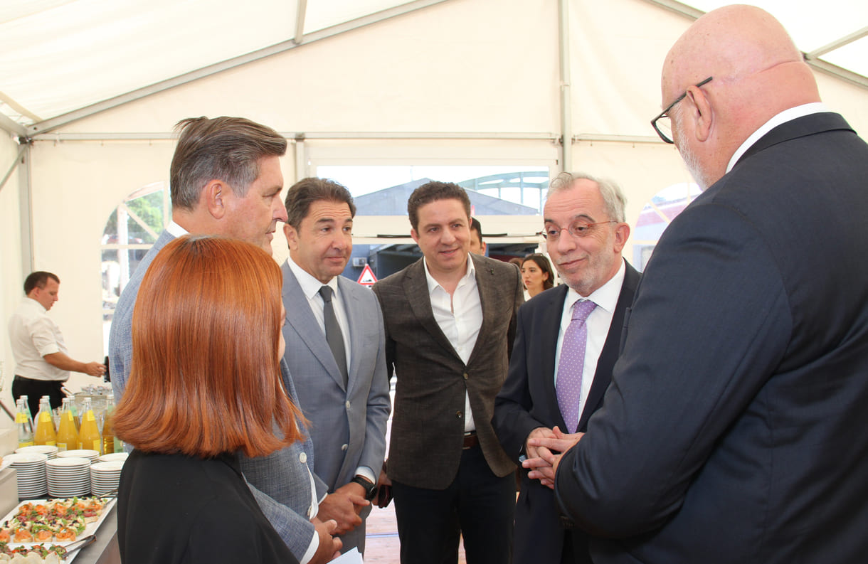 Minister, ÖBB-Chef und Pressesprecherin im Gespräch mit dem Otokar-Nutzfahrzeuge-Leiter, dem türkischen Botschafter in Österreich und einem seiner Mitarbeiter