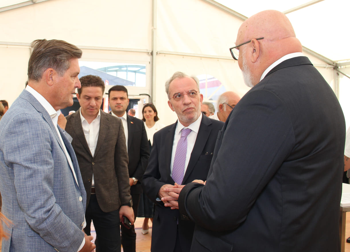 Minister, ÖBB-Chef und Pressesprecherin im Gespräch mit dem Otokar-Nutzfahrzeuge-Leiter, dem türkischen Botschafter in Österreich und einem seiner Mitarbeiter