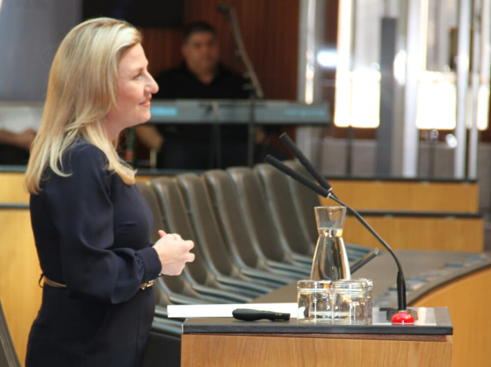 Ministerin Susanne Raab am Redepult des Plenarsaals