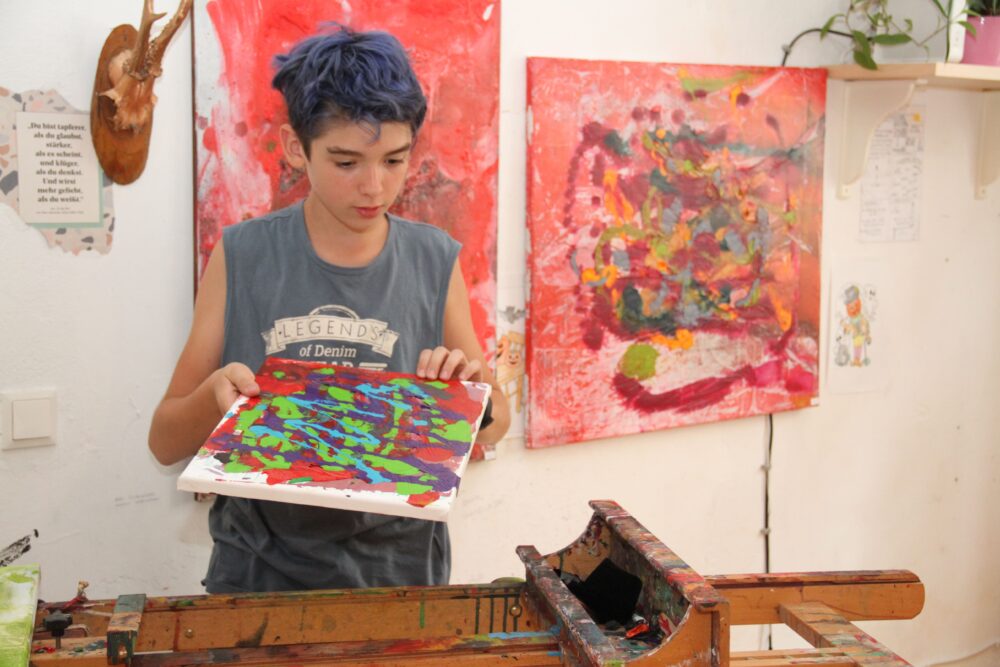 Der junge Maler mit seiner - zum Tisch umgelegten - Staffelei