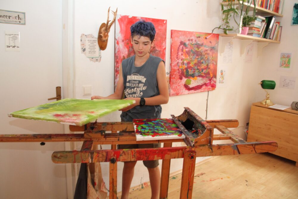 Der junge Maler mit seiner - zum Tisch umgelegten - Staffelei