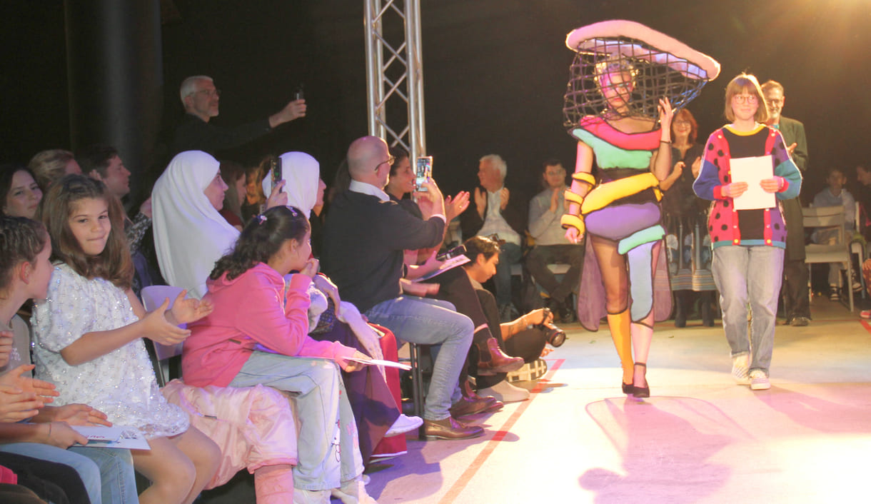 Selber im bunten, kreativen Pullover, entwarf die Siegerin in der mittleren Altersgruppe, Holly Arndold, ein farbenfrohes Kleid mit extravagantem Kopfteil
