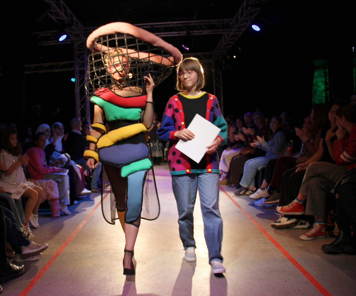Selber im bunten, kreativen Pullover, entwarf die Siegerin in der mittleren Altersgruppe, Holly Arndold, ein farbenfrohes Kleid mit extravagantem Kopfteil