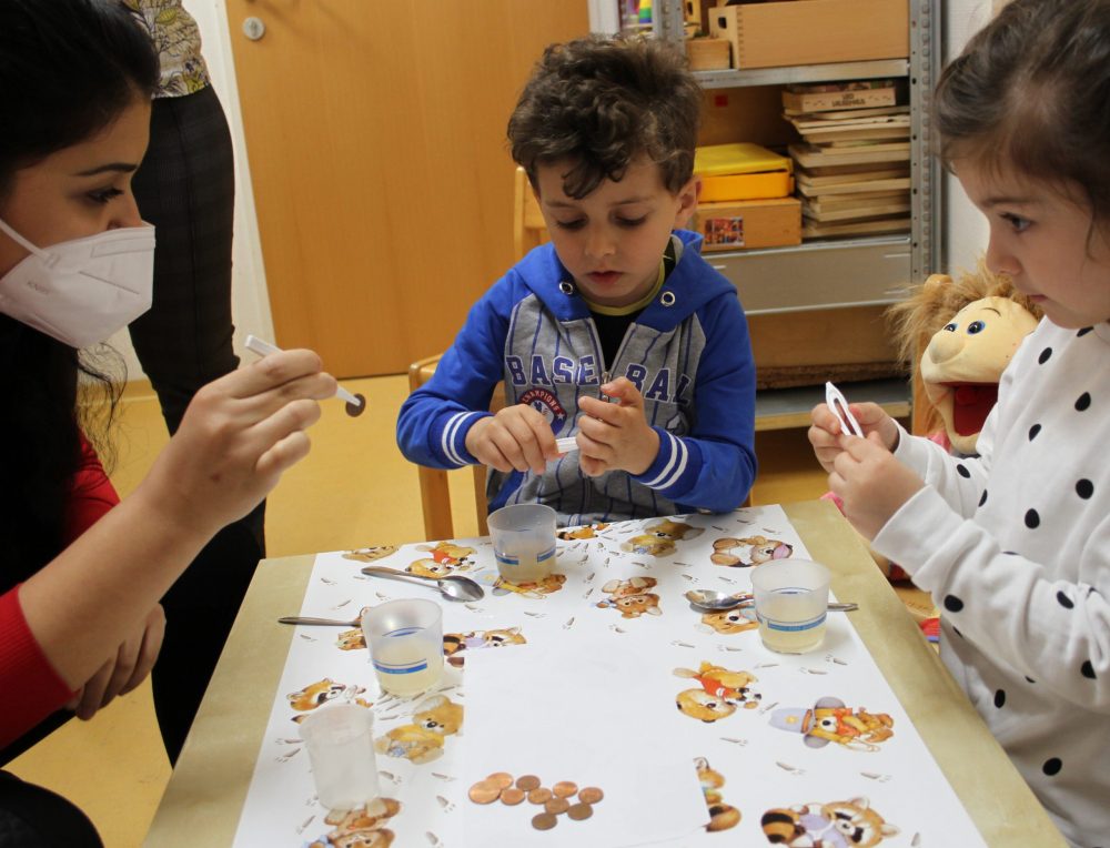 Kinder experimentieren und bringen Kupfermünzen zum Glänzen