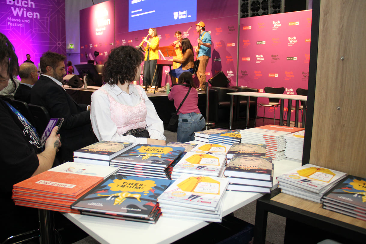 Die Preisbücher und auf der Bühne im Hintergrund spielt das 