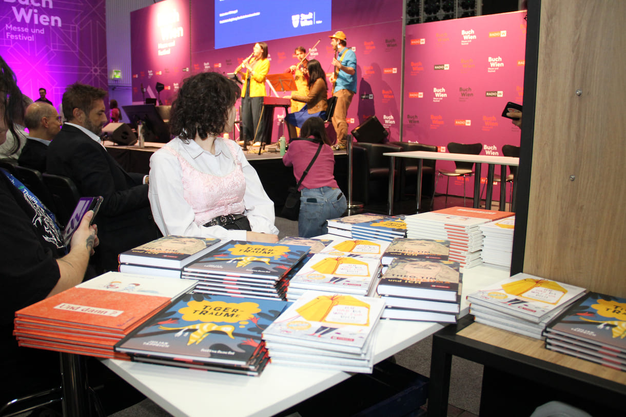 Die Preisbücher und auf der Bühne im Hintergrund spielt das 