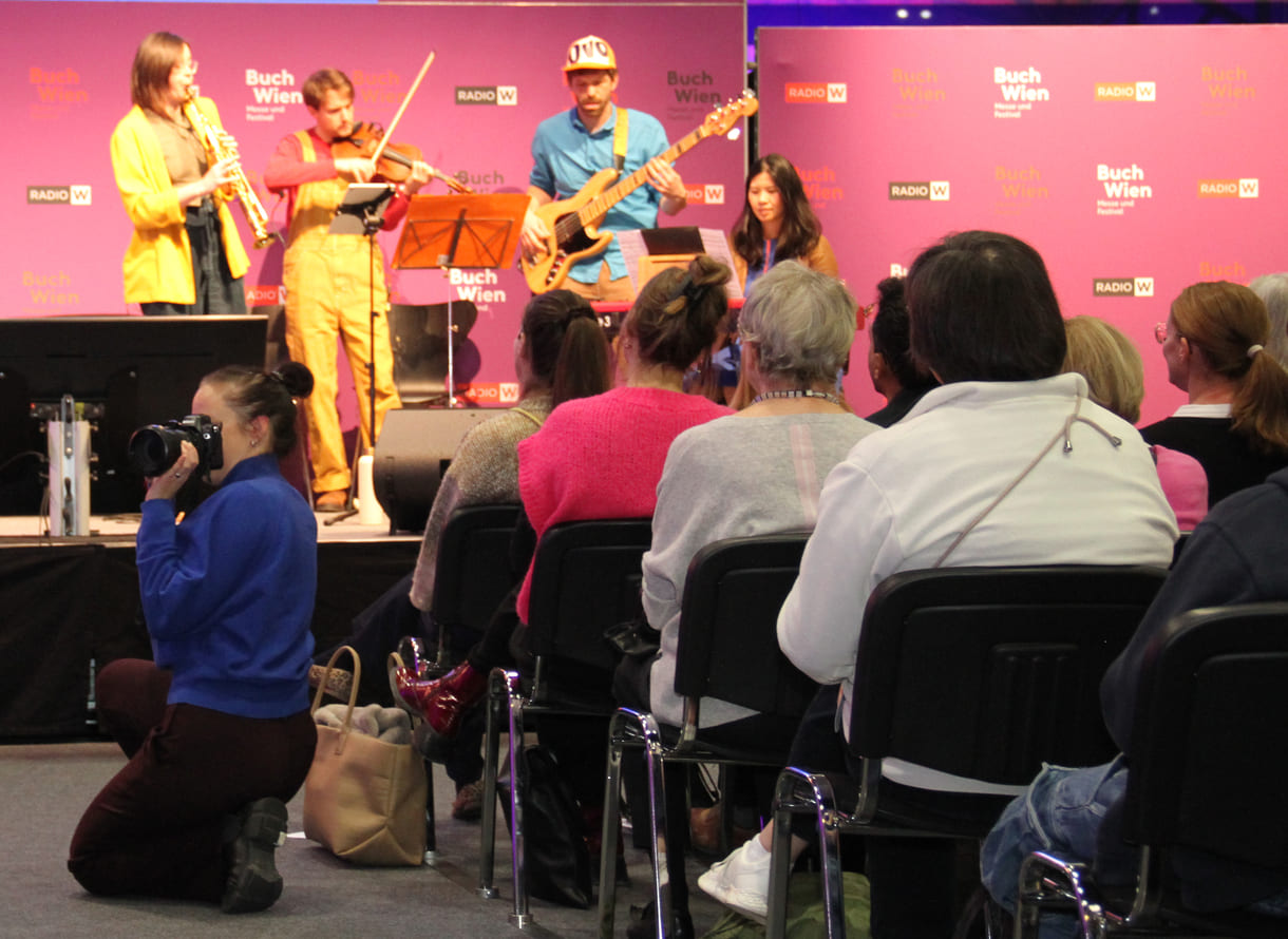 Die Preisbücher und auf der Bühne im Hintergrund spielt das 