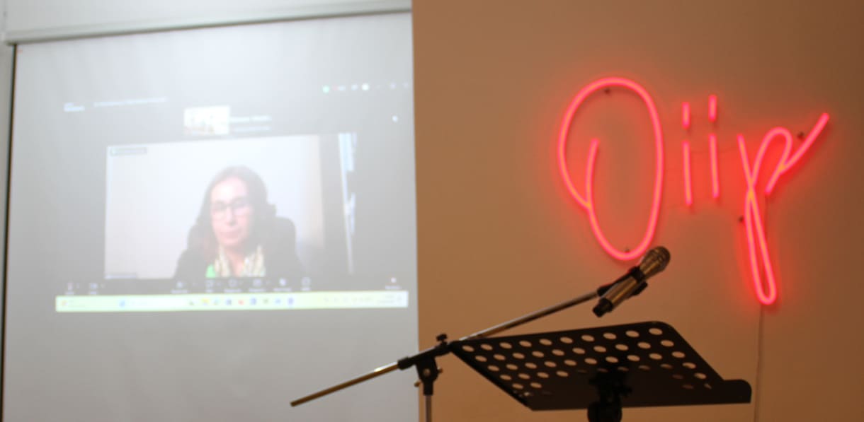 Online zugeschaltet: Manizha Bakhtari (Botschafterin Afghanistans in Österreich) - und an der Wand das leuchtende oiip-Logo
