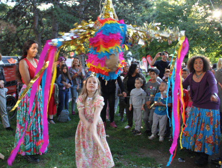 Kinder schagen auf eine bunte Karton-Piñata