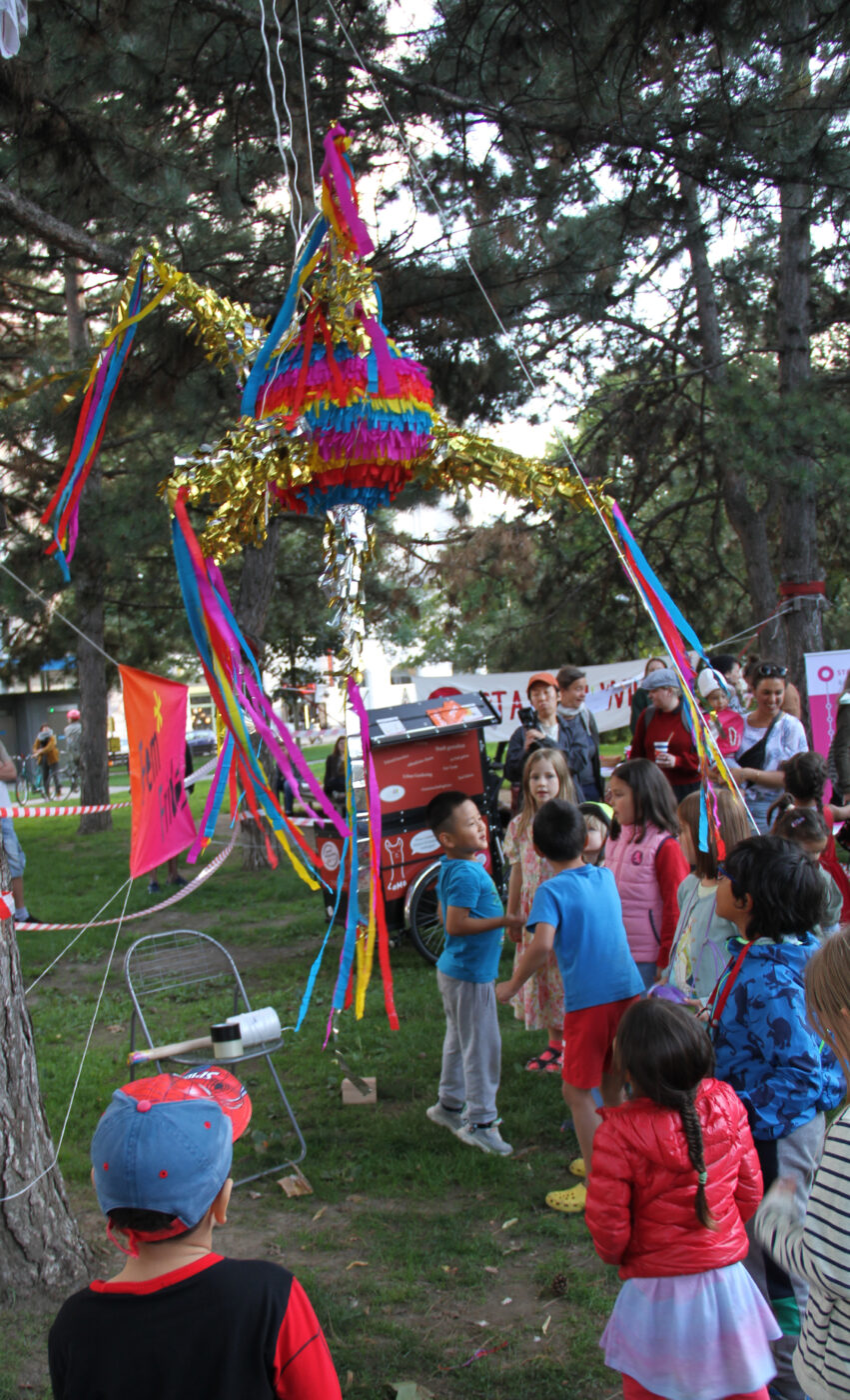 Kinder schagen auf eine bunte Karton-Piñata