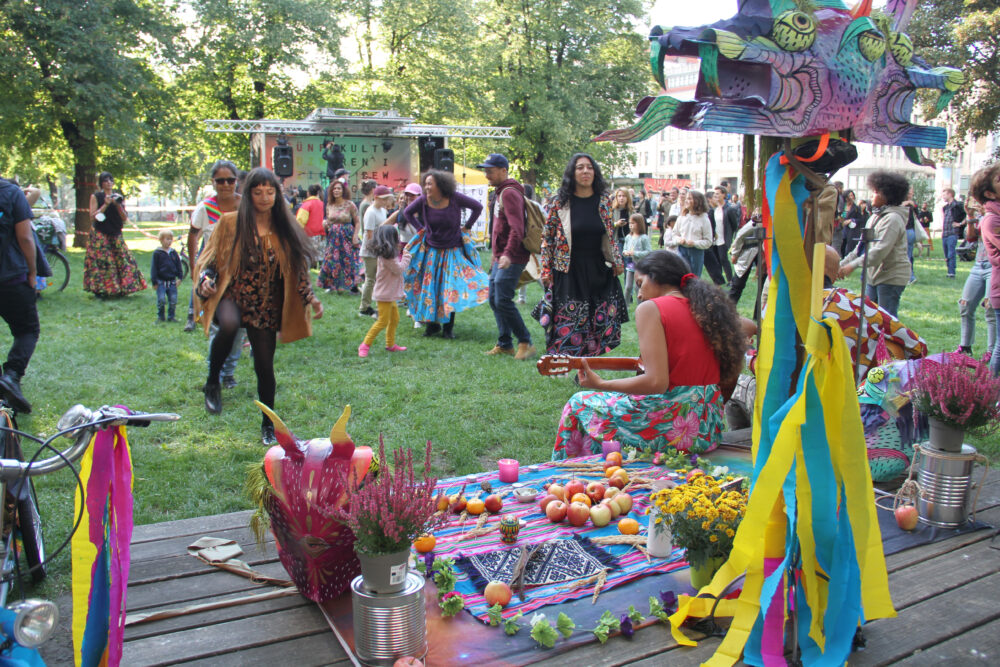 Reihentanz vor kleiner Bühne mit Piñata im Hintergrund