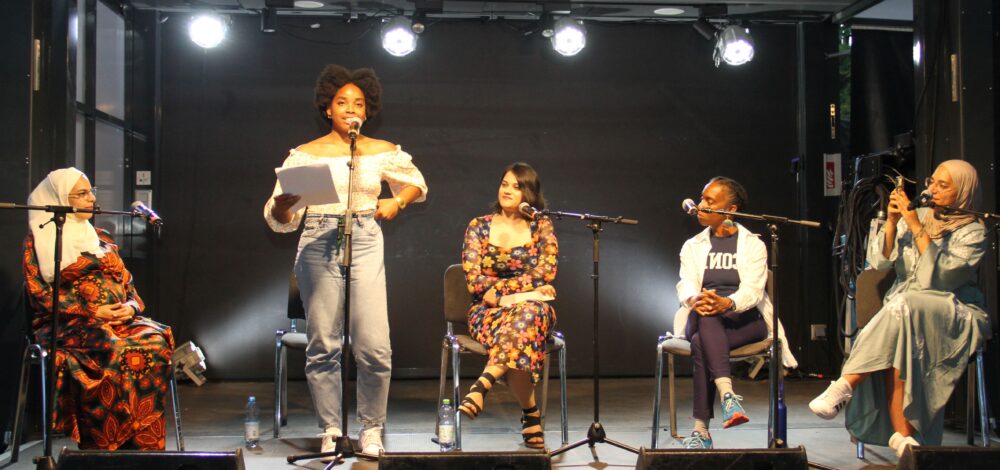 Precious Nnebedum (stehend) performt ihre Texte zweisprachig und wortakrobatisch; links: Nermin Ismail; rechts: Mehwish Sohail, Sherri Spelic sowie die Organisaotrin des Abends: Arwa Elabd