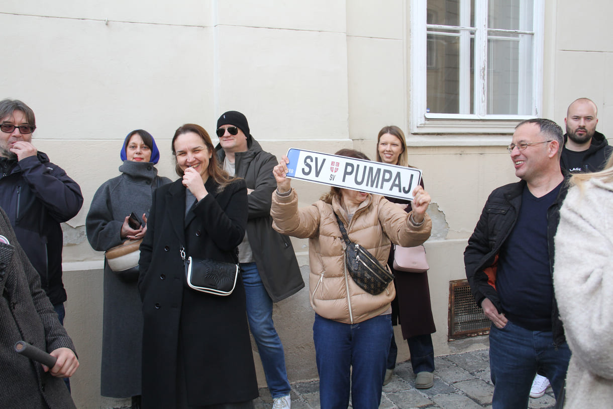 Eine Demonstrantin mit einem nachgebauten Autonummerschild mit dem Slogan 