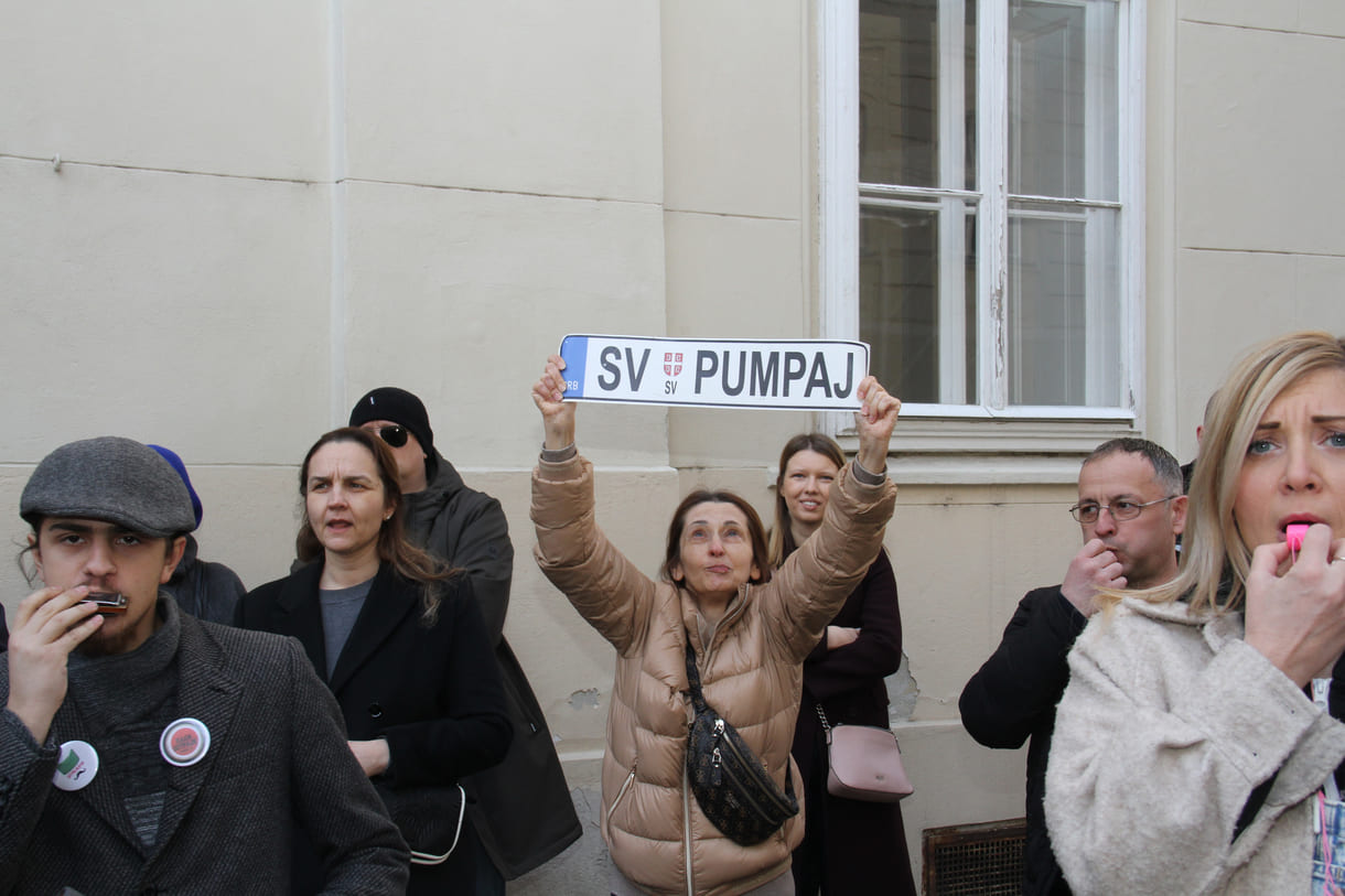 Eine Demonstrantin mit einem nachgebauten Autonummerschild mit dem Slogan 