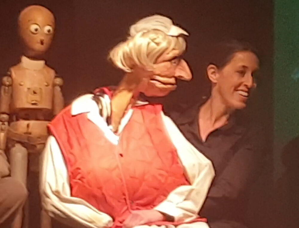Manuela Linshalm (Puppenspielerin, rechts) mit er figur der Resi Resch, Würstelstandsfrau, ganz links Holzpuppe Pinocchio