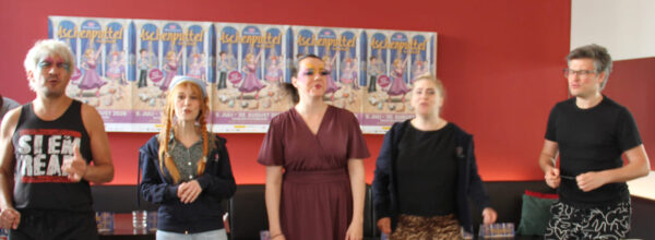 Fünf Sänger:innen vor den Plakaten für "Aschenputtel - neu getanzt" beim Märchensommer Poysbrunn