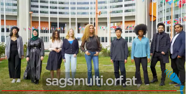 Screenshot aus dem Bewerbs-Bewerbungsvideo: moderatorin und einige Jugendliche vor dem UNO-Gebäude in Wien