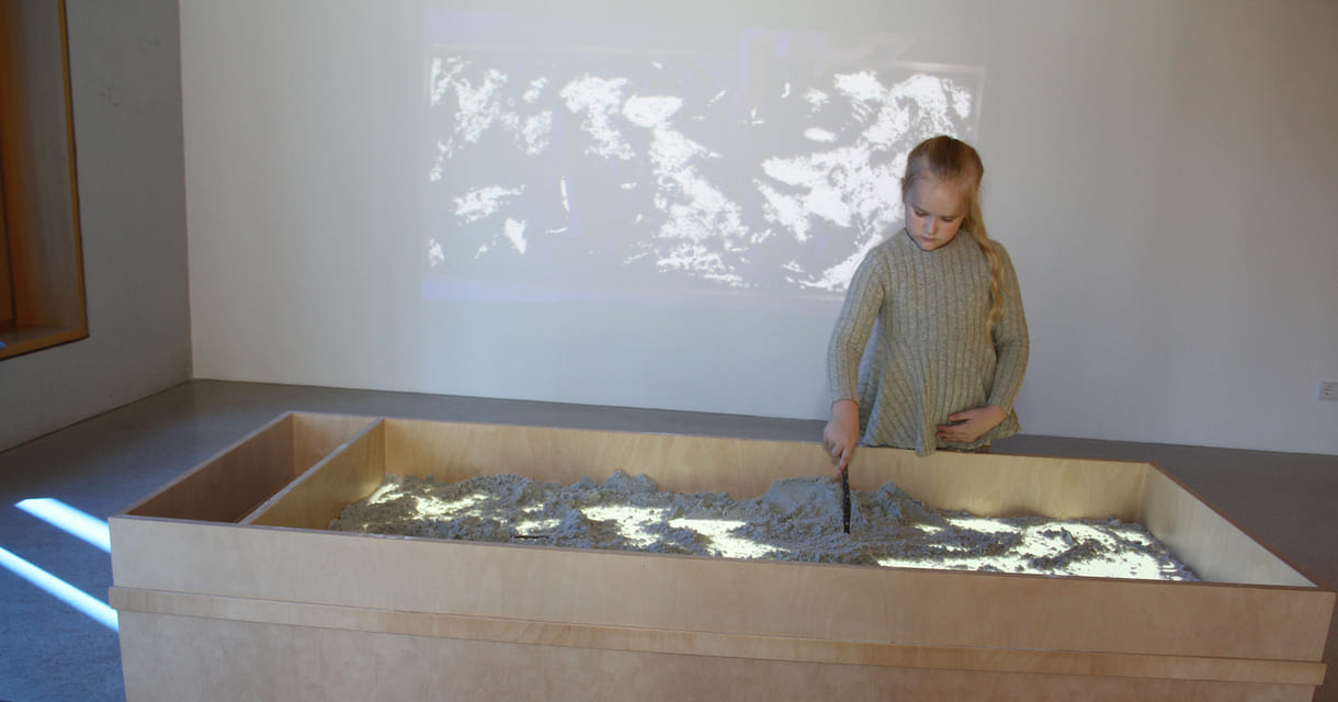 Was Kinder in diesem Sandkasten gestalten, ist als Live-Video an der Wand zu sehen