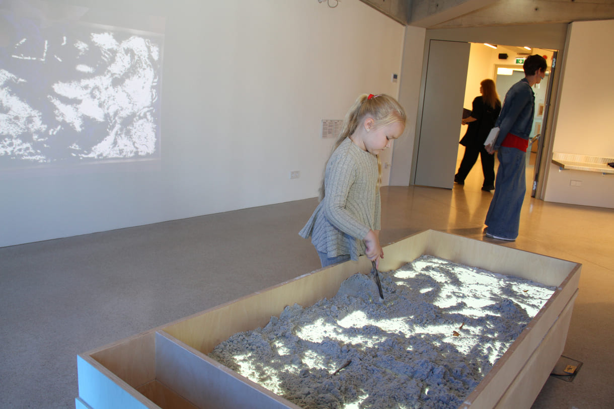 Was Kinder in diesem Sandkasten gestalten, ist als Live-Video an der Wand zu sehen