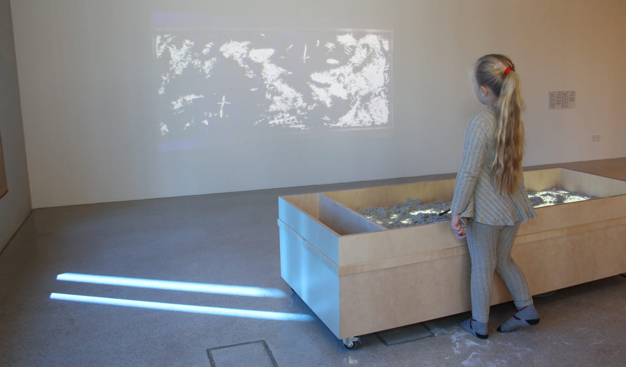 Was Kinder in diesem Sandkasten gestalten, ist als Live-Video an der Wand zu sehen