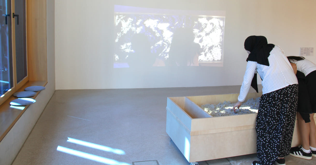 Was Kinder in diesem Sandkasten gestalten, ist als Live-Video an der Wand zu sehen