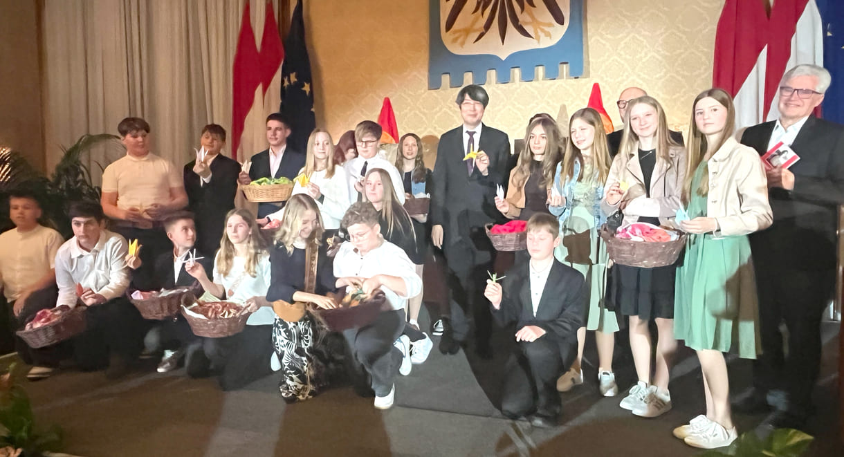 Mittelschüler:innen aus Seitenstetten Biberbach auf der Bühne mit Körben voller eigenhändig gefalteter Papierkraniche