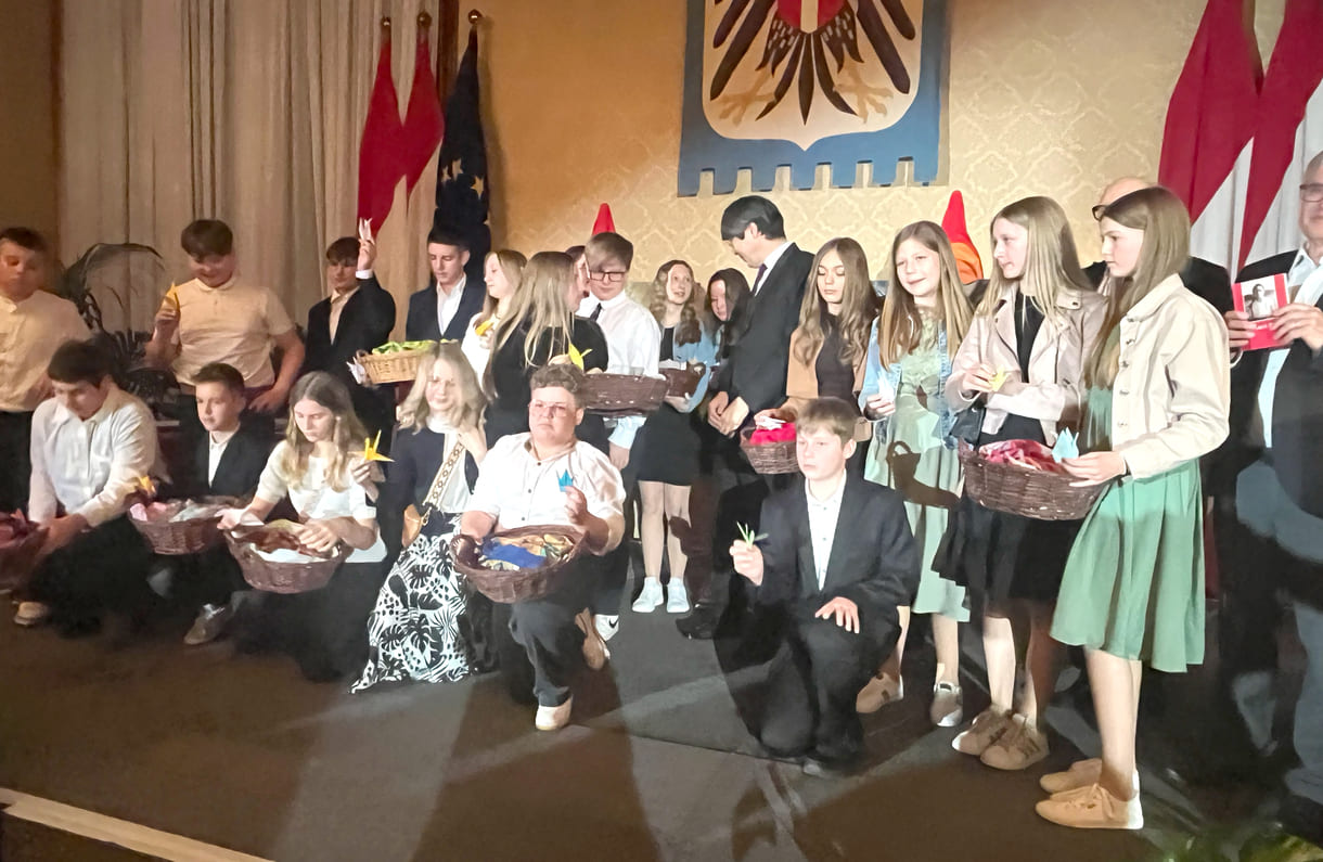 Mittelschüler:innen aus Seitenstetten Biberbach auf der Bühne mit Körben voller eigenhändig gefalteter Papierkraniche