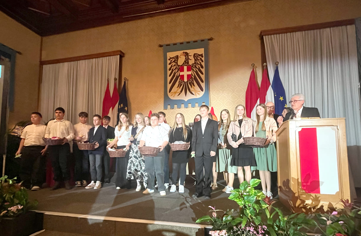 Mittelschüler:innen aus Seitenstetten Biberbach auf der Bühne mit Körben voller eigenhändig gefalteter Papierkraniche