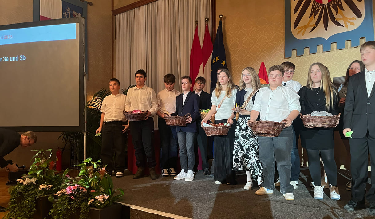 Mittelschüler:innen aus Seitenstetten Biberbach auf der Bühne mit Körben voller eigenhändig gefalteter Papierkraniche