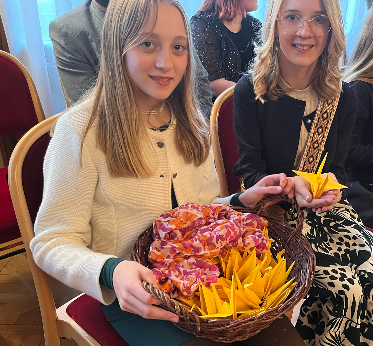 Schülerinnen mit Korb voller Origami-Kraniche