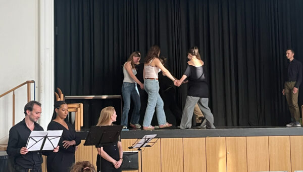 Auf der Bühne spielen Schüler:innen Szenen aus Kindheit und/oder Jugend verfolgter Jüd:innen, davor zitieren Profi-Schauspieler:innen aus den Erinnerungen dreier Verfolgter