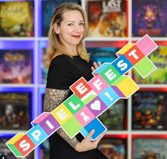 Susanne Trau mit dem tragbaren Logo des neuen Spielefestes - auf ihrem Insta-Kanal