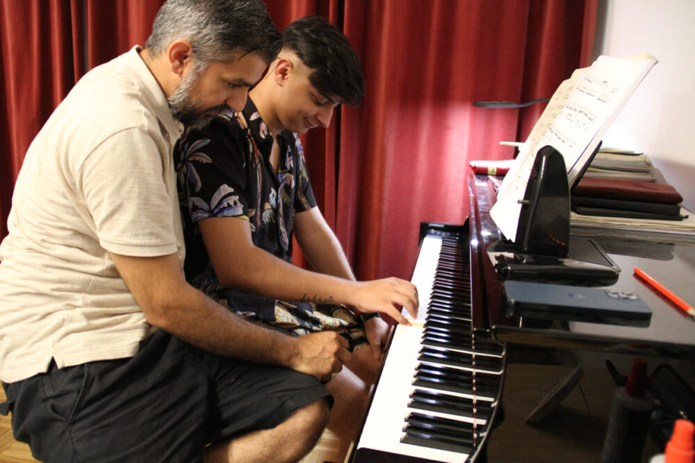 In der Academy: Slagean und Adrian spielen vierhändig am Klavier
